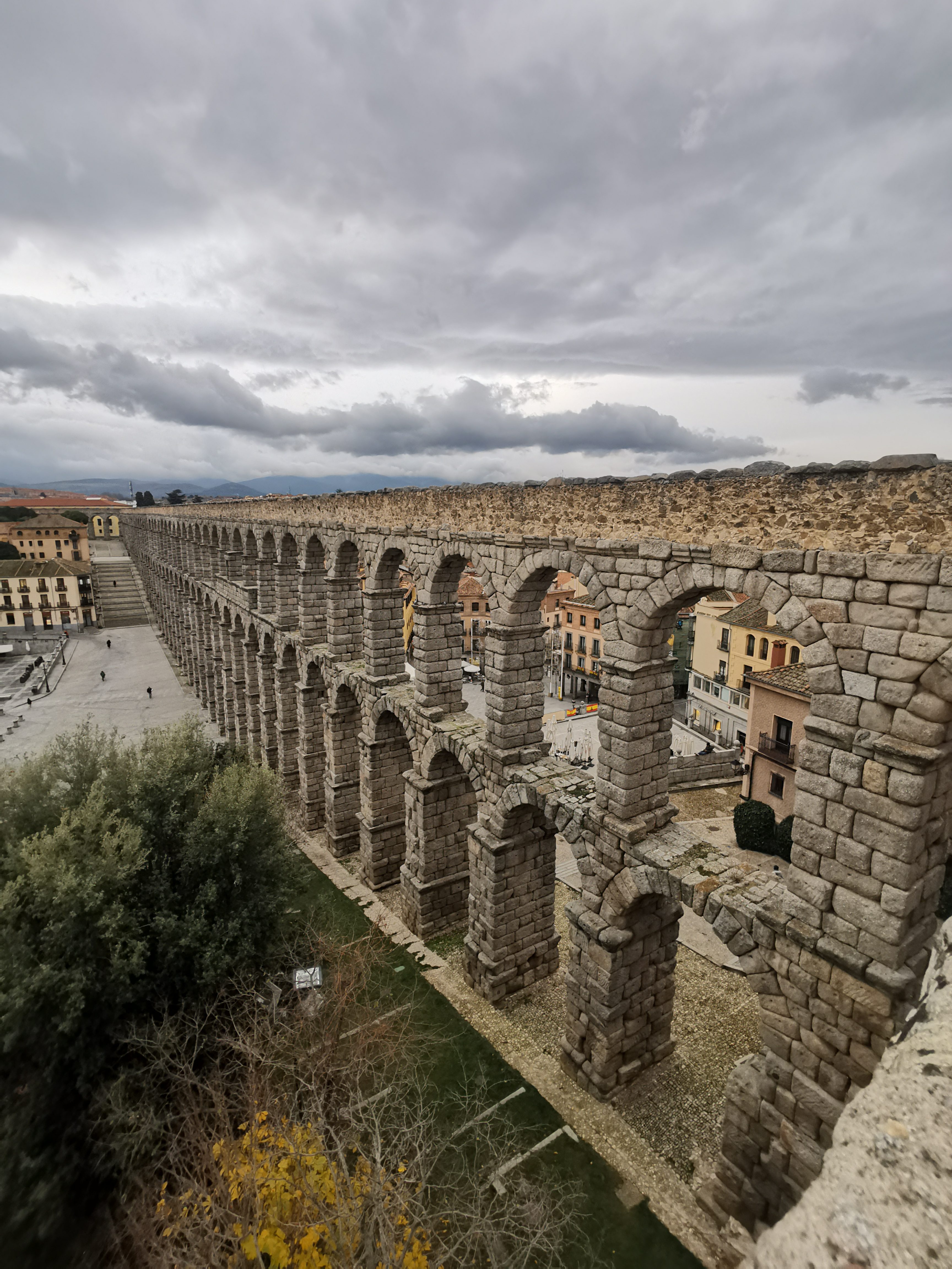 `Europe Roman Aqueduct of Segovia stretching across the old town under cloudy sky in Segovia Spain